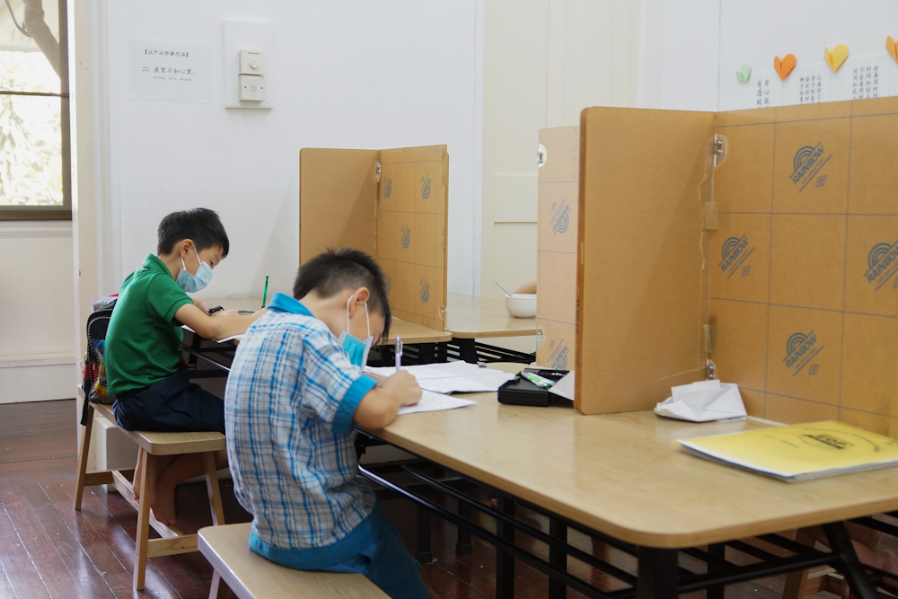 Students doing their homework in the presence of social distancing markers. (Photo by Chan May Ching) 